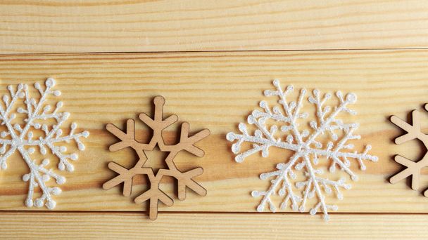 White and wooden snoflakes on wooden background. Christmas abstract background - Photo, Image