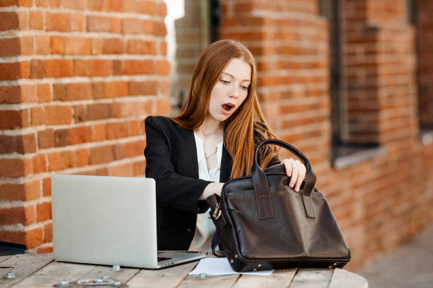 The red haired girl was surprised that she forgot important business documents - Фото, изображение