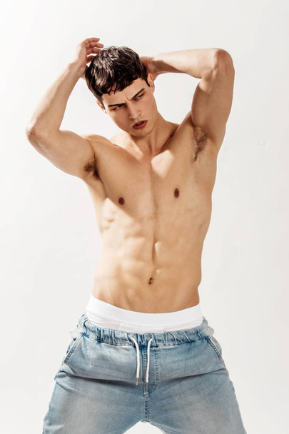 Muscle strong beautiful stripped male model in denim jeans on white isolated font background with shadow - Photo, Image