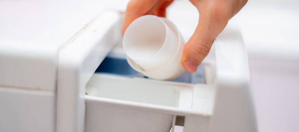 Gießen Sie die Waschanlage in die Waschmaschine, um sauberes Tuch zu bekommen - Foto, Bild