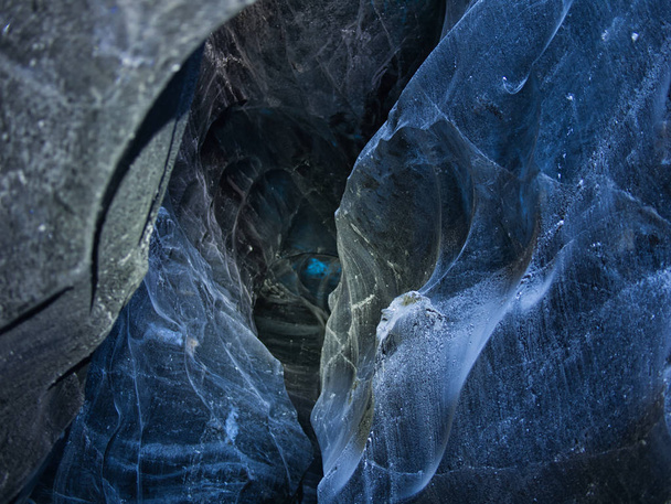 Hielo iluminado en una cueva glaciar azul
 - Foto, imagen