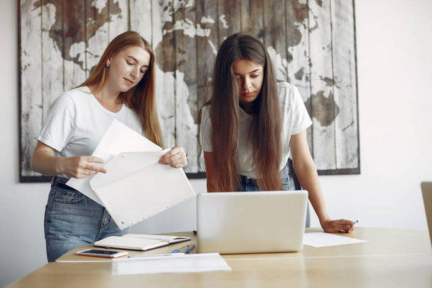 Two girls in a white t-shirts working at the office - Photo, Image