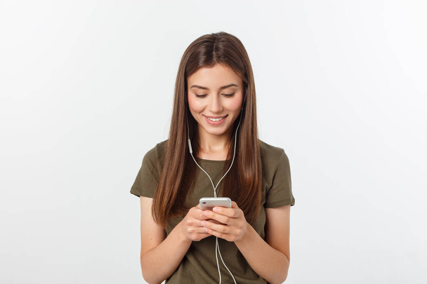 Retrato de una linda mujer alegre escuchando música en auriculares y bailando aislada sobre un fondo blanco
. - Foto, imagen