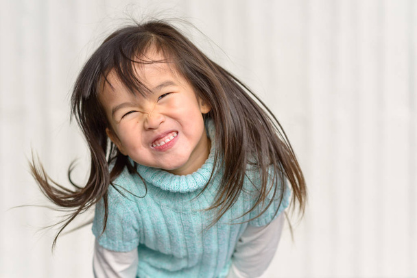 Spaß liebende kleine Mädchen werfen ihre langen Haare - Foto, Bild