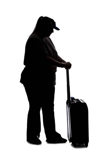 Silhouette of a curvy or plus size woman on a white background.  She is unrecognizable and is wearing casual apparel and waiting with luggage - Foto, immagini