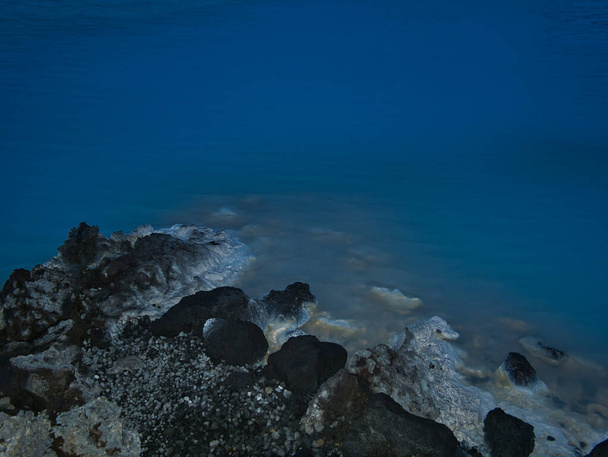 Un agua termal azul lechosa con piedras volcánicas
 - Foto, imagen