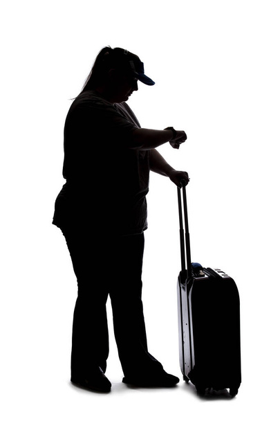 Silhouette of a curvy or plus size woman on a white background.  She is unrecognizable and is wearing casual apparel and waiting with luggage - Fotó, kép