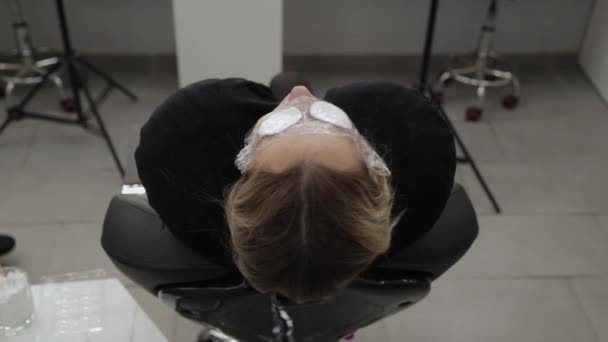 Gyönyörű nő fekszik az eljárás egy szépségszalonban pamut párna a szemét. - Felvétel, videó