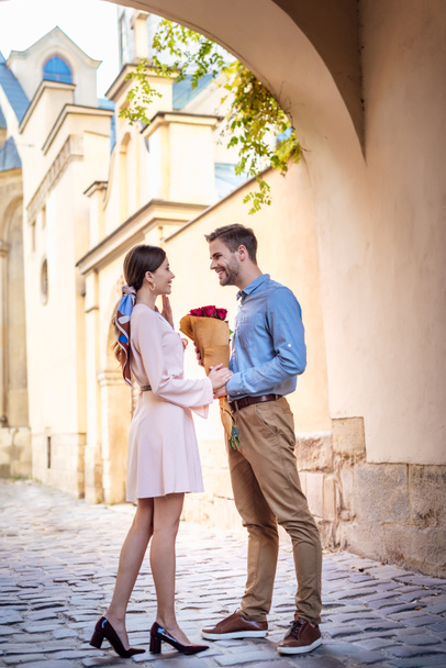jovem que apresenta buquê de rosas enquanto faz proposta de casamento com a namorada na rua
 - Foto, Imagem