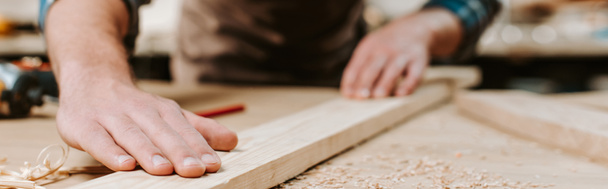 plano panorámico de carpintero tocando tablón de madera
  - Foto, Imagen