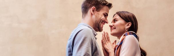 panoramic shot of happy young woman looking at boyfriend and showing please gesture - Фото, зображення