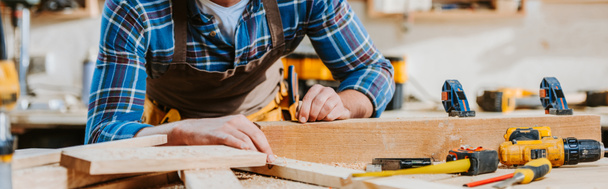 panoramic shot of carpenter touching wooden dowel  - Фото, изображение