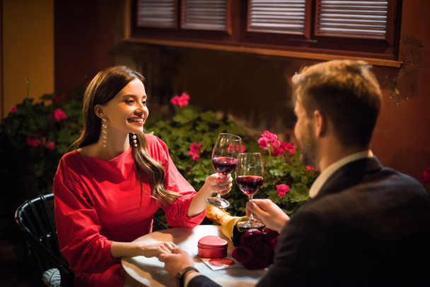 heureux fille cliquetis verres de vin rouge avec petit ami faire la demande en mariage dans le restaurant
 - Photo, image