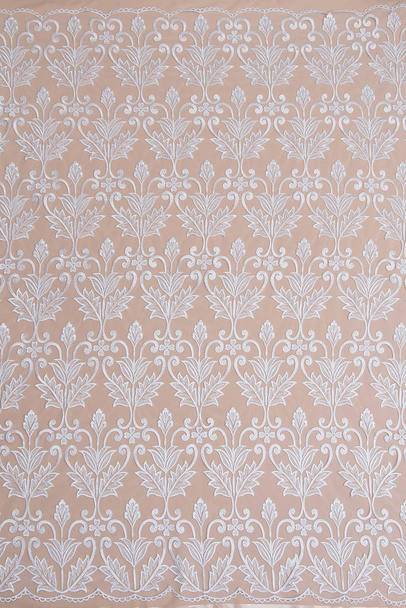 a background image of ivory-colored lace cloth. White lace on beige background. - Photo, Image