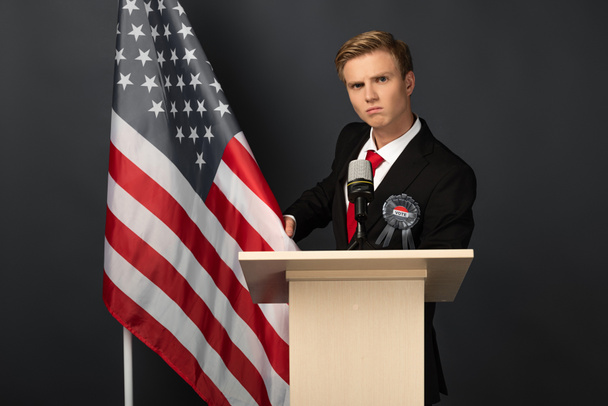 komoly férfi tribune amerikai zászló fekete háttér - Fotó, kép