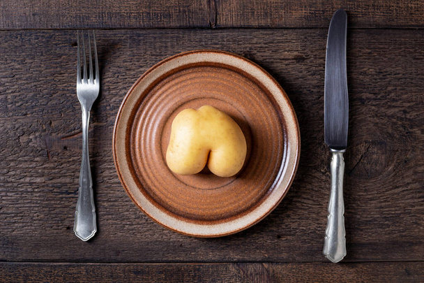 Diätkonzept - einzelne Kartoffeln in Form von Gesäß auf einem Pla - Foto, Bild