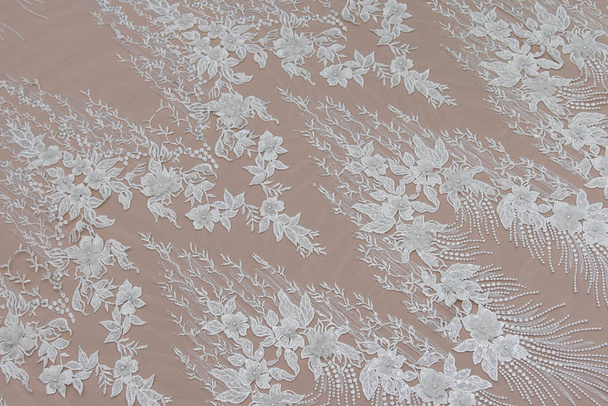 Texture lace fabric. lace on white background studio. thin fabric made of yarn or thread. a background image of ivory-colored lace cloth. White lace on beige background. - 写真・画像