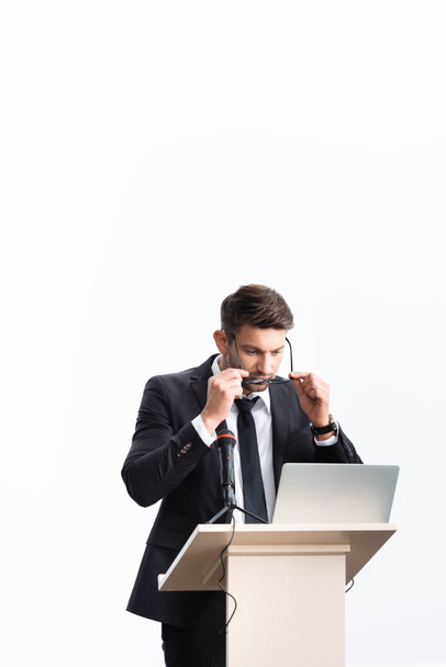 бизнесмен в костюме стоит на трибуне и носит очки во время конференции изолированы на белом
 - Фото, изображение