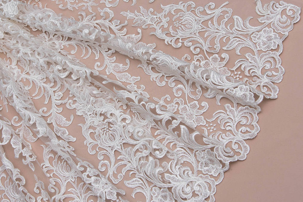 Texture lace fabric. lace on white background studio. thin fabric made of yarn or thread. a background image of ivory-colored lace cloth. White lace on beige background. - Photo, Image
