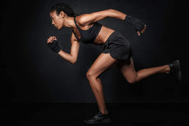 Image of african american woman in sportswear and hand wraps run - Фото, зображення