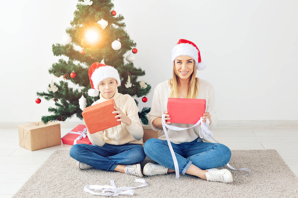 Concept de parent célibataire et vacances - Portrait de mère et fils célébrant Noël à la maison la veille de Noël
 - Photo, image