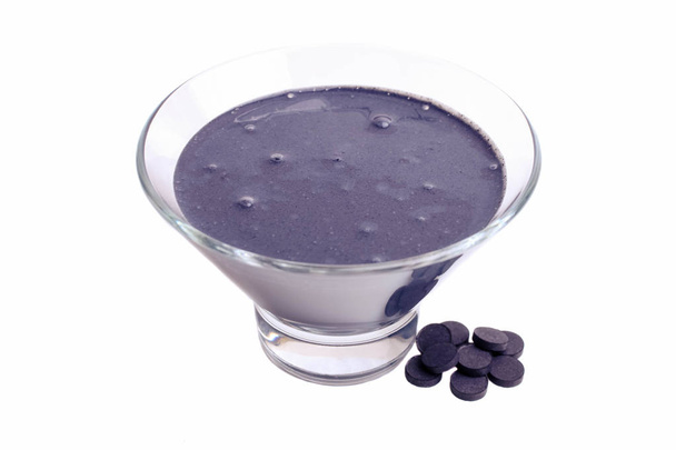 Чорний йогурт в мисці з активованими вуглецевими таблетками
 - Фото, зображення