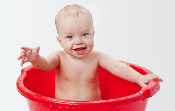 cute little babe is bathed in a basin - Φωτογραφία, εικόνα