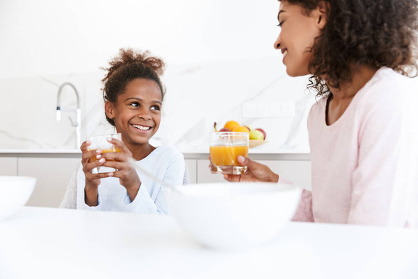 Image of american woman and her daughter having breakfast at hom - Foto, afbeelding
