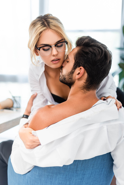 Sexy businesswoman taking off colleague shirt at office - Photo, Image