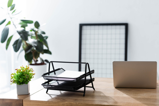Irodai asztal laptoppal és írószerrel napfényben - Fotó, kép