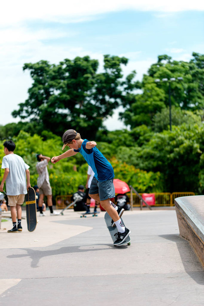 Joven niño patinador mostrando sus habilidades de patinaje al aire libre en skatepark - Foto, Imagen