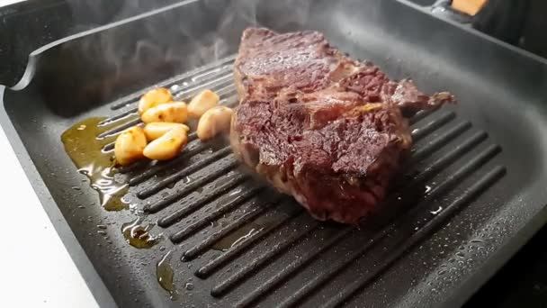 Un steak de boeuf juteux avec des clous de girofle à l'ail Cuisson sur le gril au ralenti
. - Séquence, vidéo