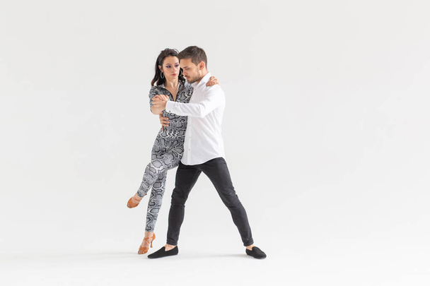 Social dance, bachata, kizomba, zouk, tango concept - Man hugs woman while dancing over white background with copy space - Foto, afbeelding
