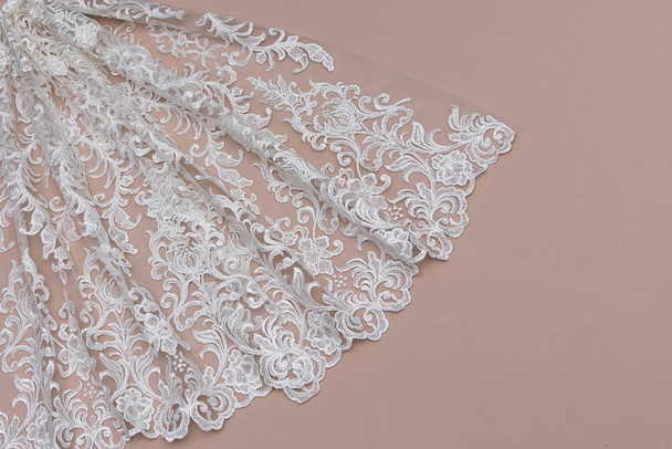 Texture lace fabric. lace on white background studio. thin fabric made of yarn or thread. a background image of ivory-colored lace cloth. White lace on beige background. - Photo, Image