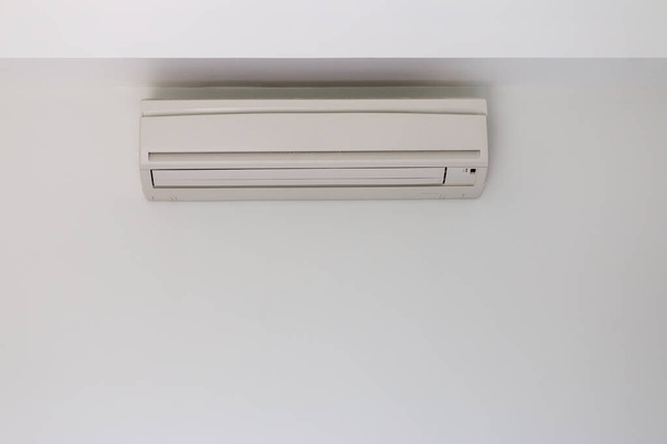 Acondicionador de aire instalado en una pared de hormigón blanco
 - Foto, imagen