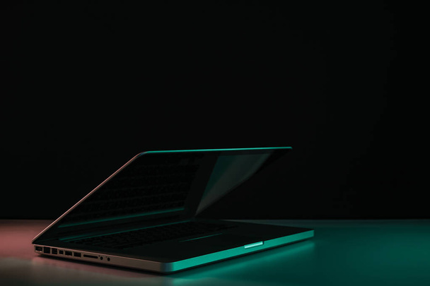 Beautiful silver laptop in the color light on a table and night background. - Photo, Image