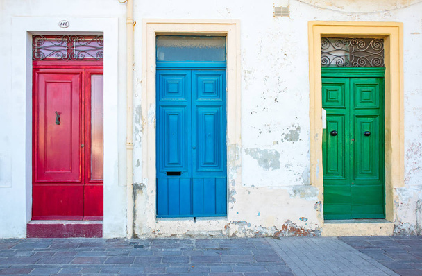 Tre porte tipiche maltesi nel villaggio di Marsaxlokk. Rosso, blu, porte verdi. Paese di Malta
 - Foto, immagini