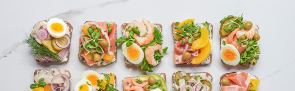 панорамный снимок свежих и вкусных сэндвичей из смореброда на поверхности белого мрамора
  - Фото, изображение
