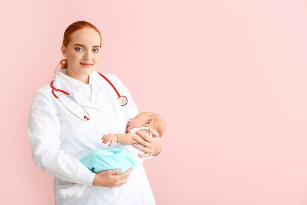 Pediatrician with cute baby on color background - Fotografie, Obrázek