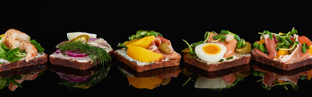 plan panoramique de pain de seigle avec de savoureux sandwichs danois smorrebrod sur noir
  - Photo, image