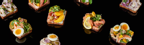 colpo panoramico di pane di segale con gustosi panini allo smorrebrod danese su nero
  - Foto, immagini