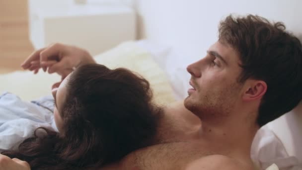 Macro of young married couple lying in bedroom. Cute woman head on man chest. - Séquence, vidéo