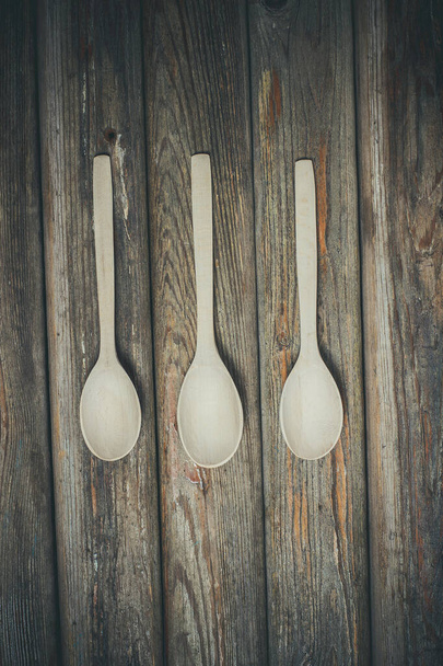 Beautiful bright wooden spoons for food and spices. - Фото, изображение