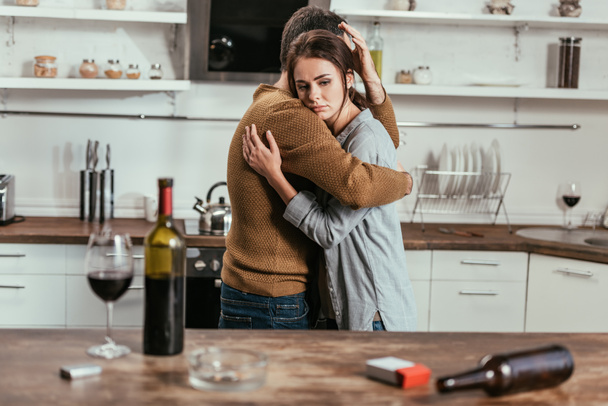 Szelektív fókusz a férfi támogató feleség alkoholfüggőség a konyhában - Fotó, kép