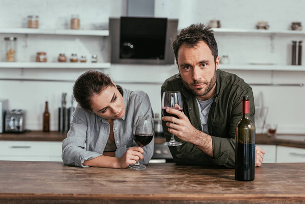 Alcohol pareja adicta beber vino en la cocina
 - Foto, Imagen