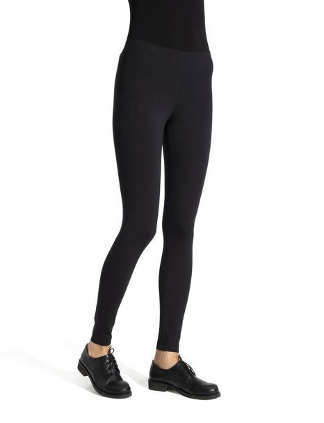 Woman wear black blank leggings mockup, isolated, clipping path. Women in clear leggins template. Cloth pants design presentation. Sport pantaloons stretch tights model wearing. Slim legs in apparel - Photo, image