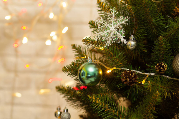 Beautiful green Christmas tree decorated with balls and garlands. Close-up photo. Sparkling background - Foto, immagini