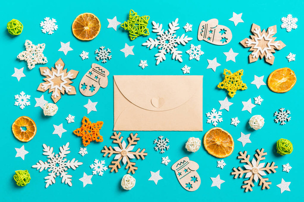 Top view of craft envelope on blue background with New Year toys and decorations. Christmas time concept - Fotografie, Obrázek