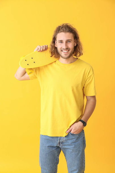 Retrato de hombre feliz con monopatín sobre fondo de color
 - Foto, Imagen