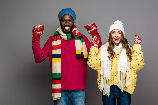 happy interracial couple in winter outfit showing yes gesture on grey background - 写真・画像